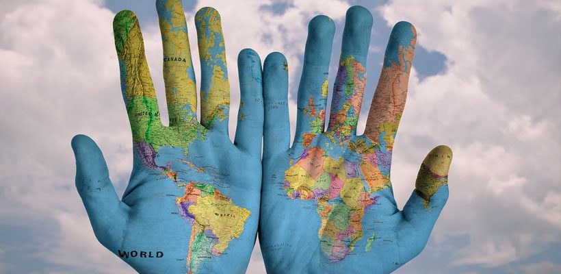 World's map painted on hands that are praying