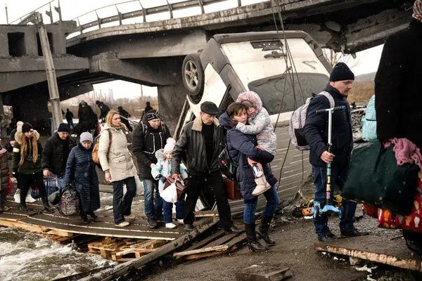 Ukranian people crossing bridge in a queue during wartime