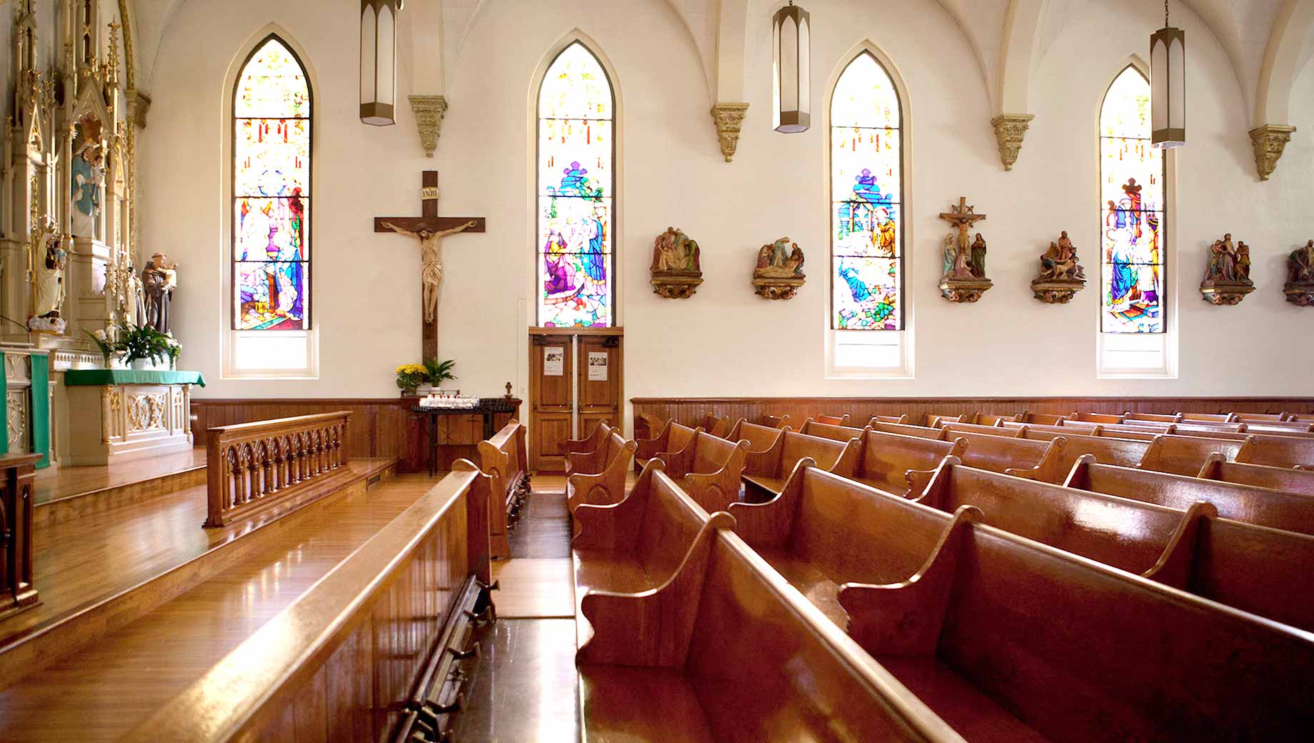 An inside view of the church that contains brown wooden benches