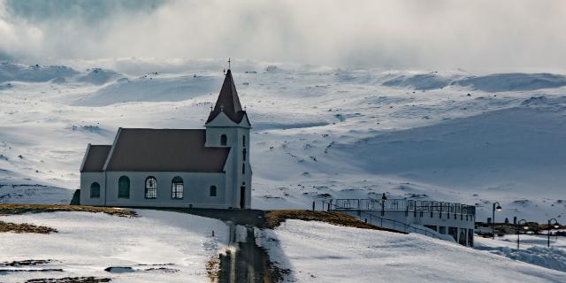 A beautiful distant shot of a church on a land covered with snow
