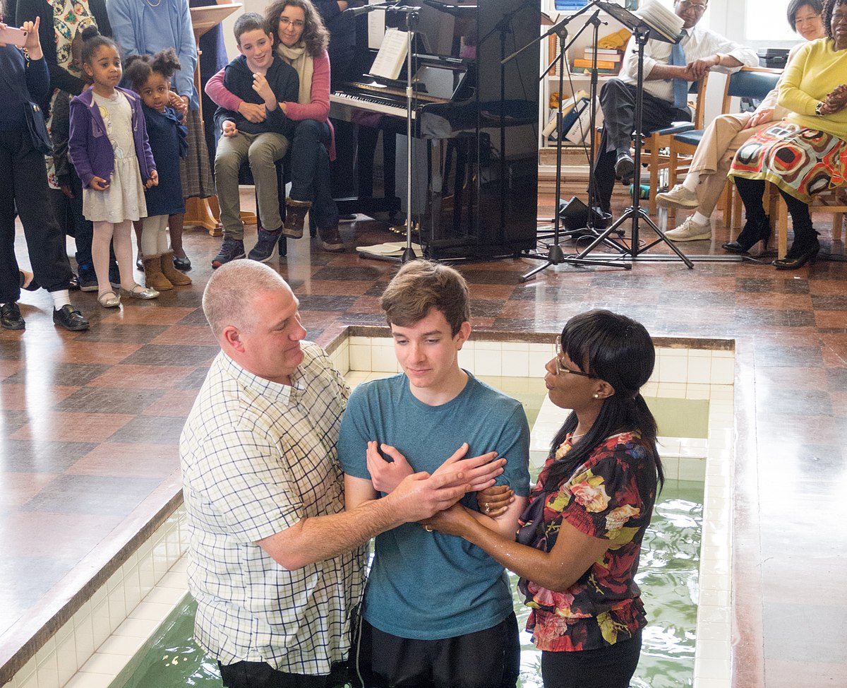 Two parents holding their kid before baptism