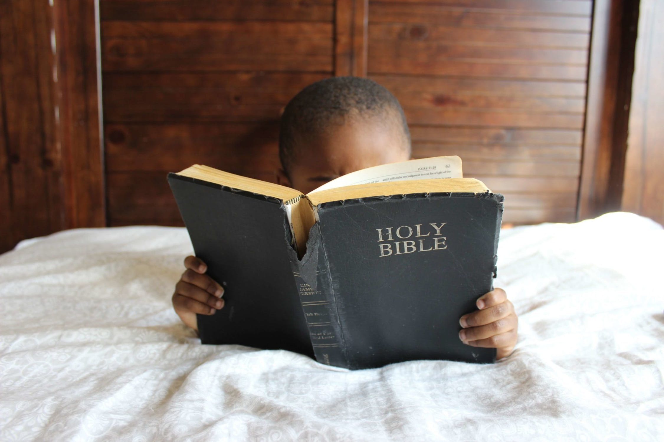 A kid reading Holy Bible