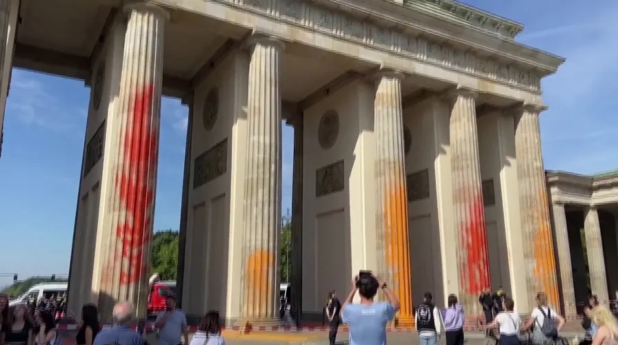 German climate activists demanding a stop to fossil fuel use by 2030 spray painted the Brandenburg Gate in Berlin, orange and yellow.